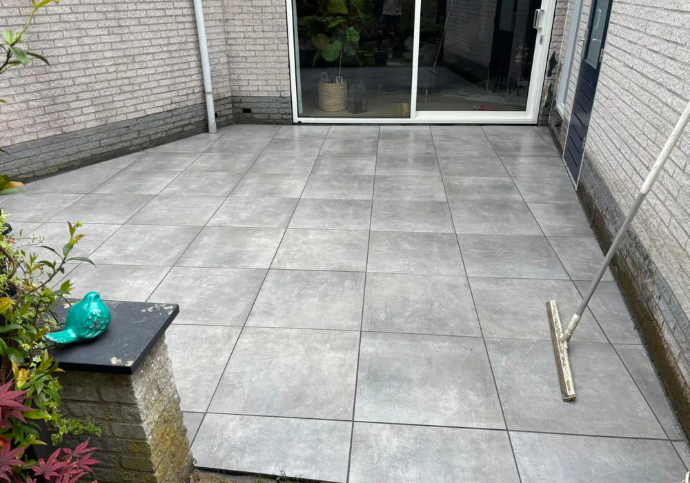 Terras in grote grijze tegels, gelegd door B&N Bestratingen